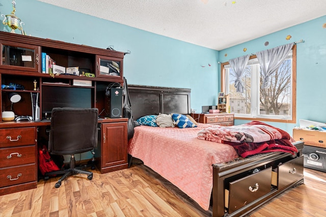 bedroom with a textured ceiling and light wood-style flooring