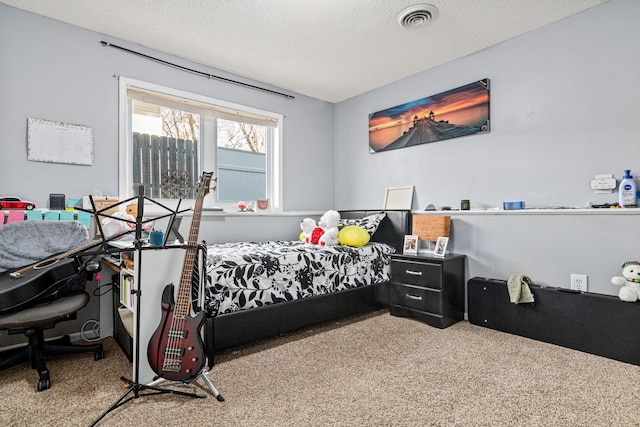 bedroom with carpet floors, a textured ceiling, and visible vents