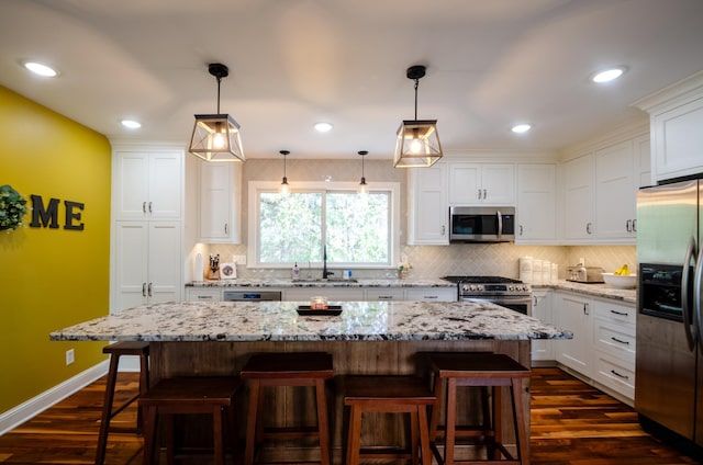 kitchen with appliances with stainless steel finishes, decorative backsplash, a sink, and dark wood-type flooring