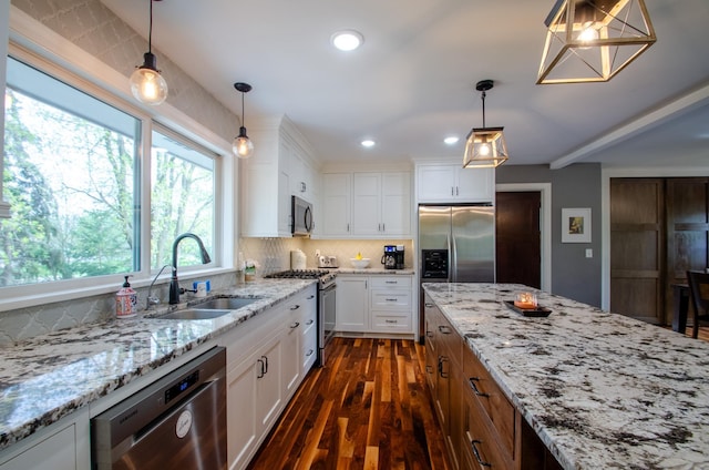 kitchen featuring decorative backsplash, white cabinetry, a sink, dark wood finished floors, and appliances with stainless steel finishes