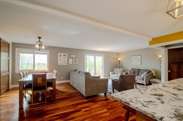 dining room featuring baseboards, dark wood finished floors, and beamed ceiling