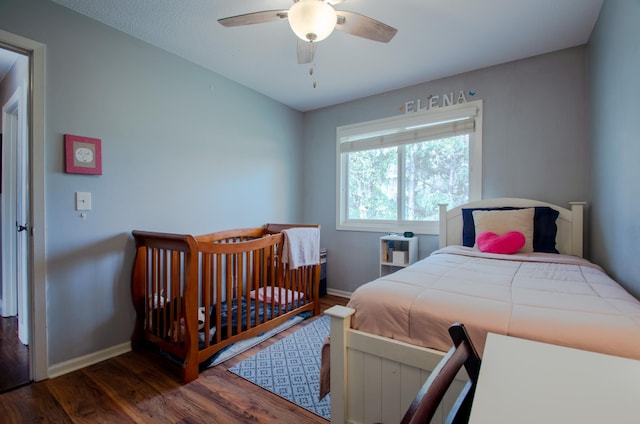 bedroom featuring baseboards, ceiling fan, and wood finished floors