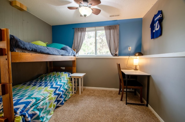 bedroom with carpet, a ceiling fan, a textured ceiling, and visible vents