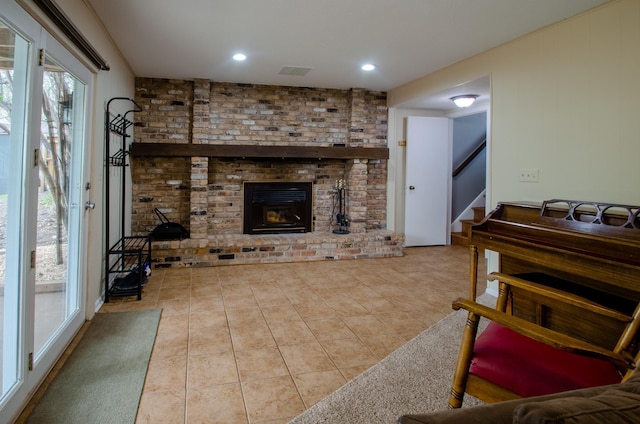 living room with a healthy amount of sunlight, tile patterned floors, stairway, and visible vents
