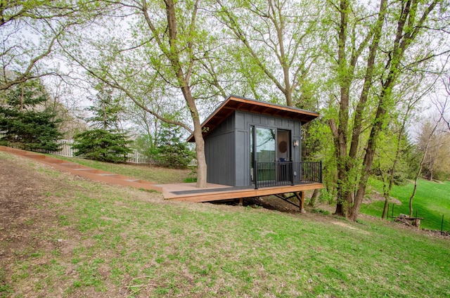 view of outbuilding featuring fence and an outdoor structure