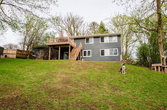rear view of house featuring a lawn, fence, stairs, and a deck
