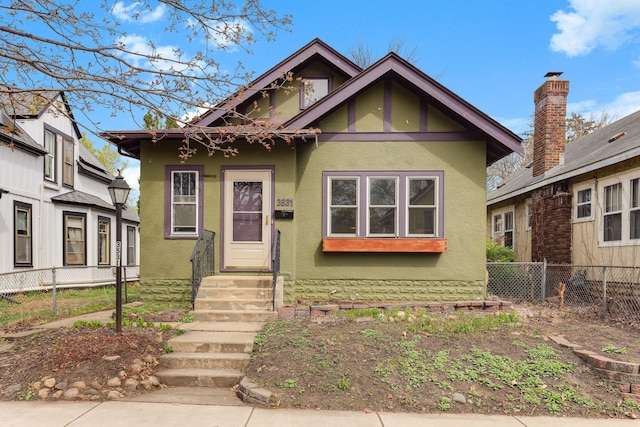 bungalow featuring fence, entry steps, and stucco siding