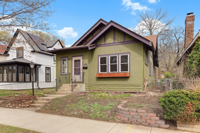 bungalow featuring stucco siding, a chimney, fence, and a sunroom