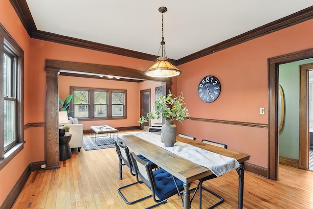 dining area with crown molding, baseboards, and light wood finished floors