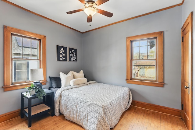 bedroom featuring crown molding, baseboards, a ceiling fan, and light wood finished floors