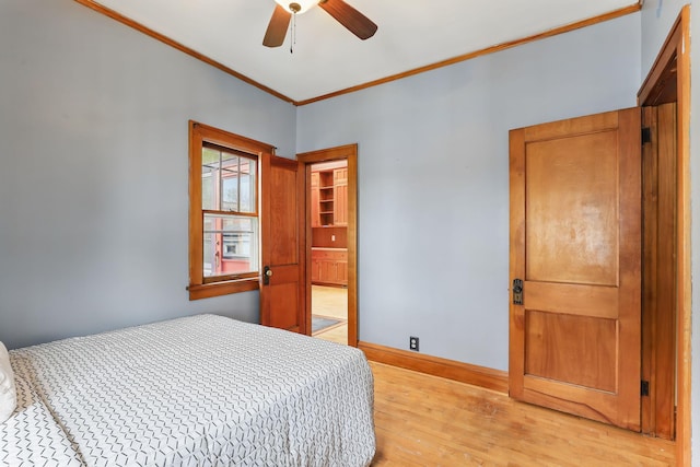 bedroom with baseboards, ceiling fan, ornamental molding, and light wood-style flooring