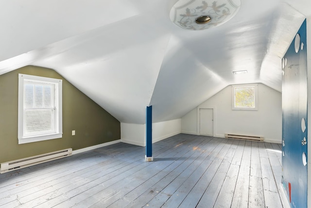 additional living space featuring baseboard heating, vaulted ceiling, and hardwood / wood-style flooring