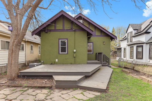 back of house with central AC, stucco siding, a deck, and fence