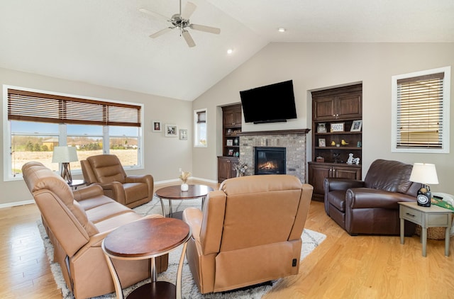 1006 9th Street Ct SE, New Prague, MN 56071 - living area featuring light wood-type flooring, a ceiling fan, high vaulted ceiling, baseboards, and a glass covered fireplace