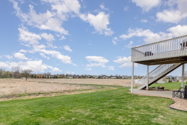 1006 9th Street Ct SE, New Prague, MN 56071 - view of grassy yard with stairs, a wooden deck, a patio, and a view of rural / pastoral area