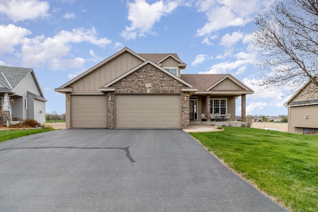 1006 9th Street Ct SE, New Prague, MN 56071 - craftsman house with board and batten siding, brick siding, a front lawn, asphalt driveway, and a garage