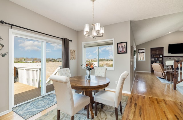 1006 9th Street Ct SE, New Prague, MN 56071 - dining room featuring a chandelier, light wood-style flooring, healthy amount of natural light, and vaulted ceiling