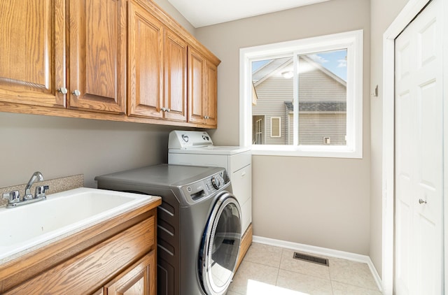 1006 9th Street Ct SE, New Prague, MN 56071 - clothes washing area featuring washer and clothes dryer, baseboards, cabinet space, and light tile patterned floors