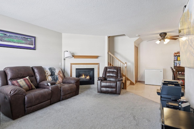 5085 149th St N # 3, Hugo, MN 55038 - carpeted living area with ceiling fan, a tile fireplace, stairs, and a textured ceiling