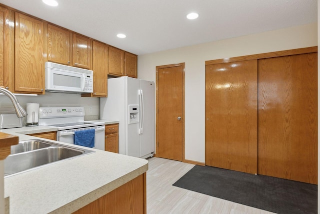 5085 149th St N # 3, Hugo, MN 55038 - kitchen with white appliances, light countertops, a sink, recessed lighting, and brown cabinetry