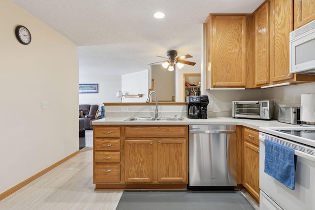 5085 149th St N # 3, Hugo, MN 55038 - kitchen with white appliances, a sink, a peninsula, ceiling fan, and light countertops