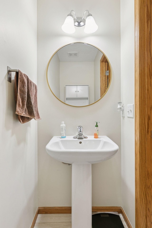 5085 149th St N # 3, Hugo, MN 55038 - bathroom featuring baseboards, a sink, and wood finished floors