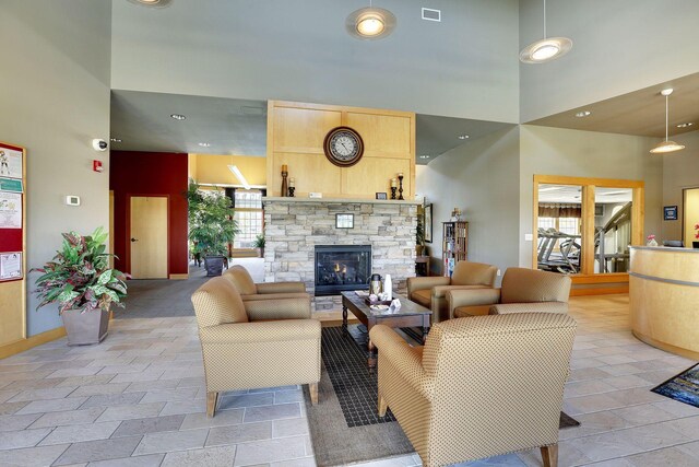 5085 149th St N # 3, Hugo, MN 55038 - living room featuring a towering ceiling, a stone fireplace, light tile patterned floors, recessed lighting, and baseboards