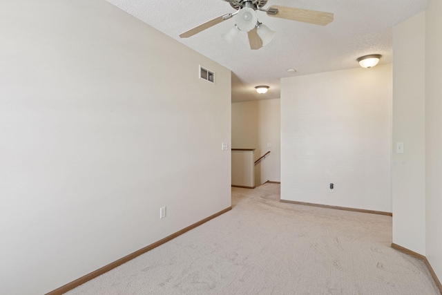 5085 149th St N # 3, Hugo, MN 55038 - spare room featuring light carpet, baseboards, ceiling fan, and a textured ceiling