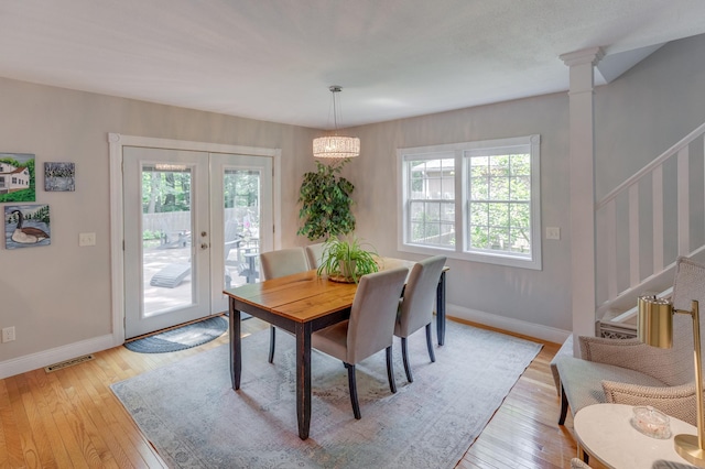 dining area featuring plenty of natural light, light wood-style floors, stairs, and visible vents