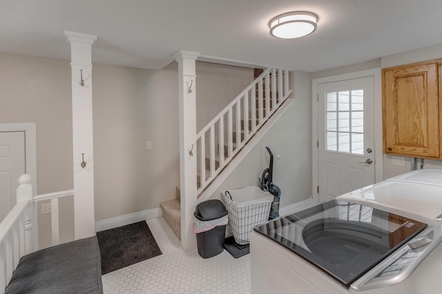 clothes washing area featuring independent washer and dryer, baseboards, and cabinet space