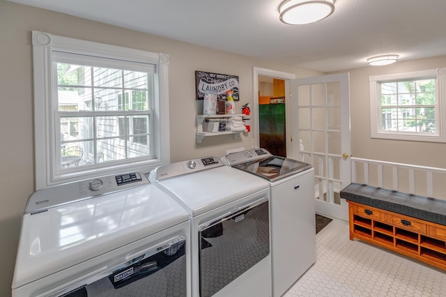 clothes washing area with french doors, laundry area, and washer and clothes dryer