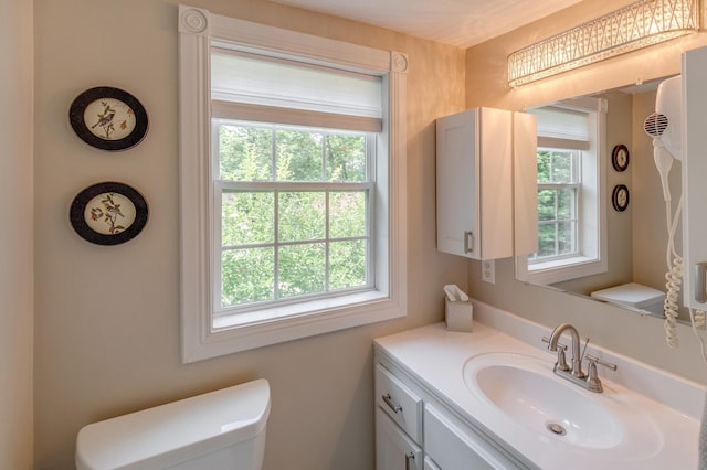 half bathroom featuring vanity and toilet