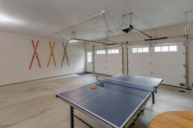 recreation room featuring a garage, a textured ceiling, and concrete flooring