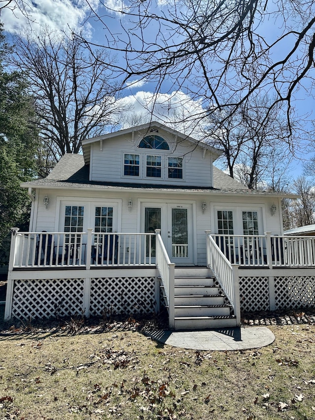 back of property with french doors, a shingled roof, and a deck