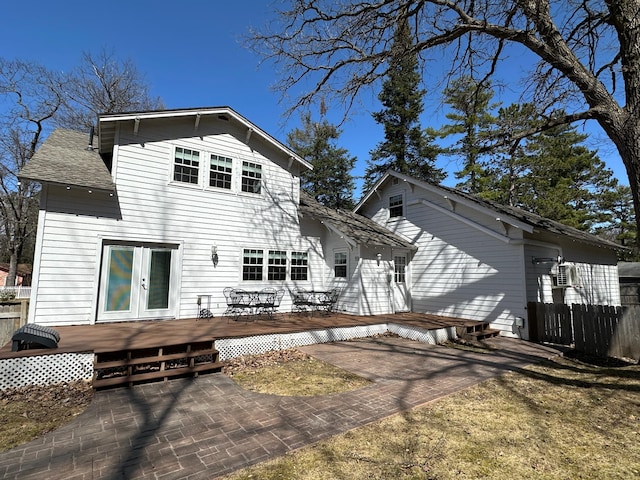 back of property featuring a deck, fence, and french doors