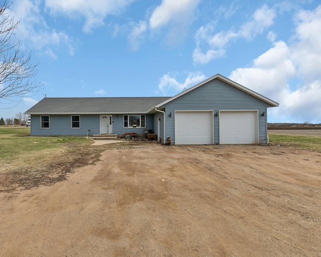 single story home featuring a garage and dirt driveway