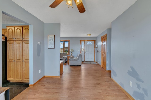 entryway with ceiling fan, baseboards, and light wood finished floors