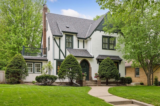 1722 Pinehurst Ave, Saint Paul, MN 55116 - tudor home featuring stucco siding, a chimney, a balcony, a front yard, and a shingled roof