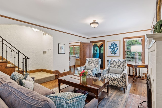 1722 Pinehurst Ave, Saint Paul, MN 55116 - living area featuring arched walkways, wood finished floors, a textured wall, stairs, and ornamental molding