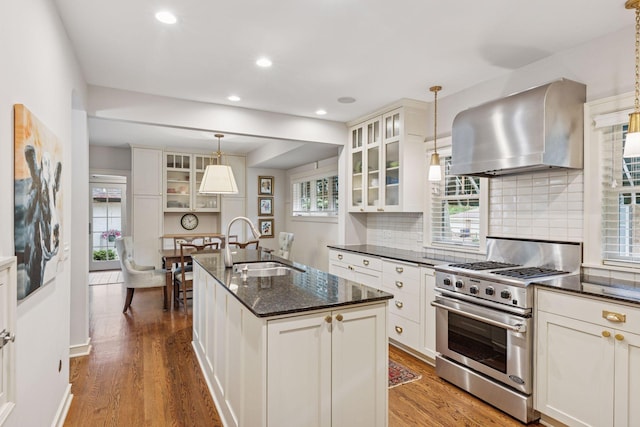 1722 Pinehurst Ave, Saint Paul, MN 55116 - kitchen with wall chimney exhaust hood, high end range, a sink, wood finished floors, and tasteful backsplash