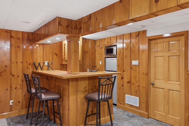 1722 Pinehurst Ave, Saint Paul, MN 55116 - indoor bar featuring stainless steel microwave, wood walls, and baseboards
