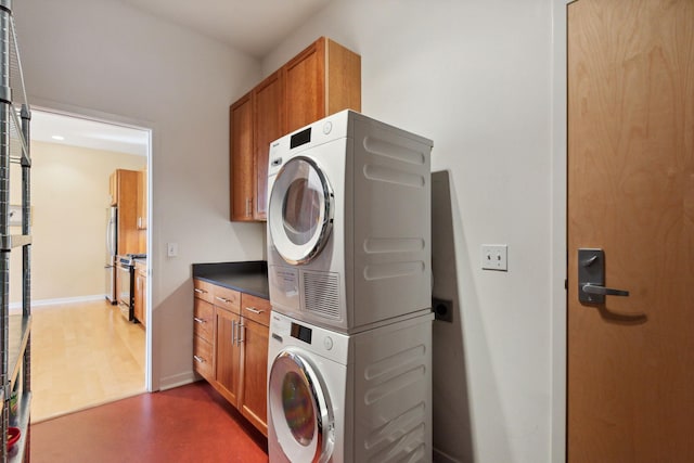 490 Temperance St Unit 403, Saint Paul, MN 55101 - laundry room with baseboards, stacked washer and clothes dryer, and cabinet space