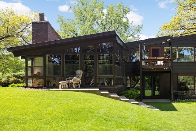 4618 Cedarwood Rd, Saint Louis Park, MN 55416 - rear view of property with a chimney, a yard, a wooden deck, and a sunroom