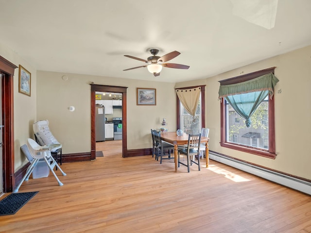 3213 Minnehaha Ave, Minneapolis, MN 55406 - dining area featuring baseboard heating, light wood-style floors, baseboards, and ceiling fan