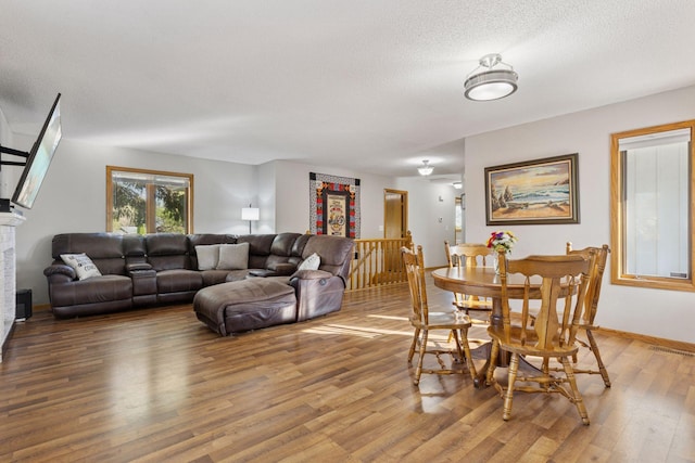 dining space with light wood finished floors, a textured ceiling, and visible vents