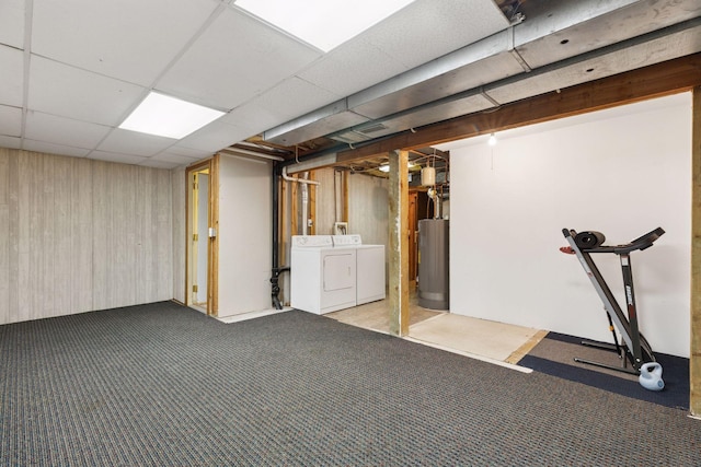 below grade area with wooden walls, carpet, washing machine and dryer, and water heater