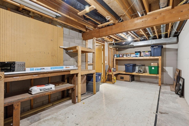unfinished below grade area with a workshop area and tile patterned floors