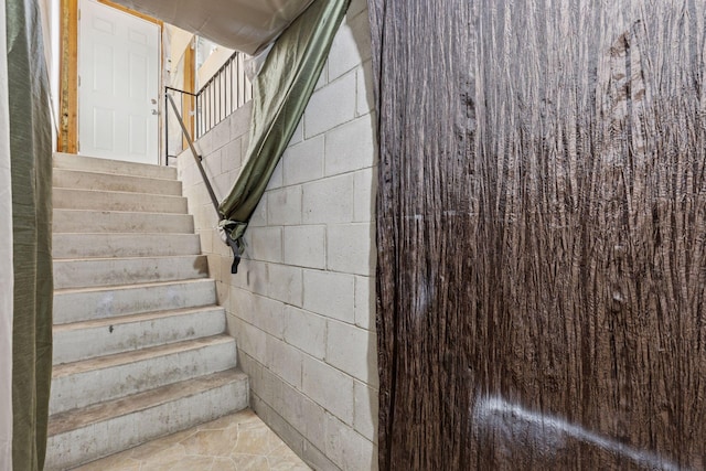 stairs featuring concrete block wall