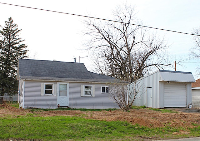 exterior space with aphalt driveway, an outbuilding, and a detached garage