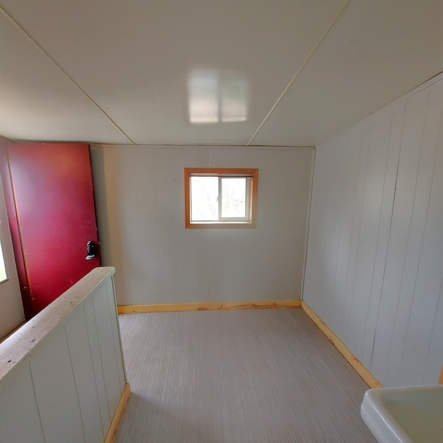 spare room with baseboards and wood walls